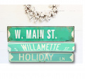 A nicely designed white wall with three retired street signs used for decor