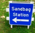standing sign with arrow and text reading sandbag station