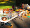 a table full of a variety of items for sale at a yard sale 