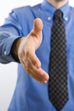 image of a business man with a tie reaching out for a handshake