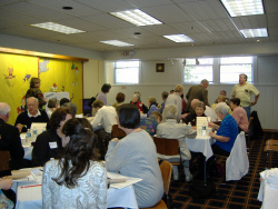 The Austin Room filled with tables and people talking at a meeting 