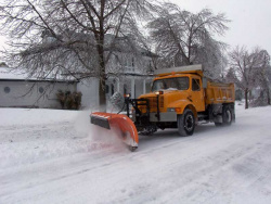 A snow plow clearing a residential street