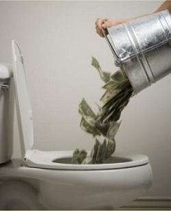 A person dumping money from a bucket down a toilet