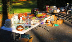 a table full of a variety of items for sale at a yard sale 