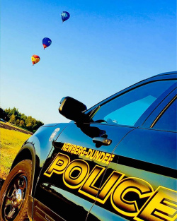 police car with hot air balloons in the background
